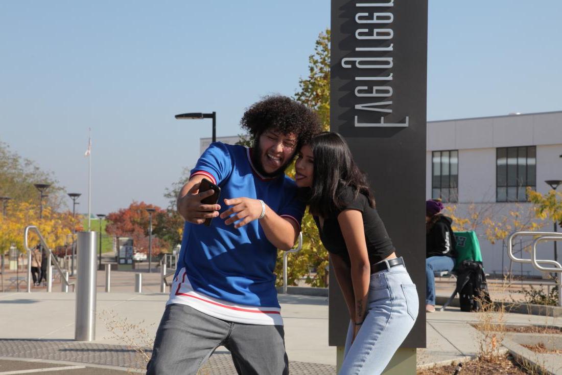 two students looking at their phone